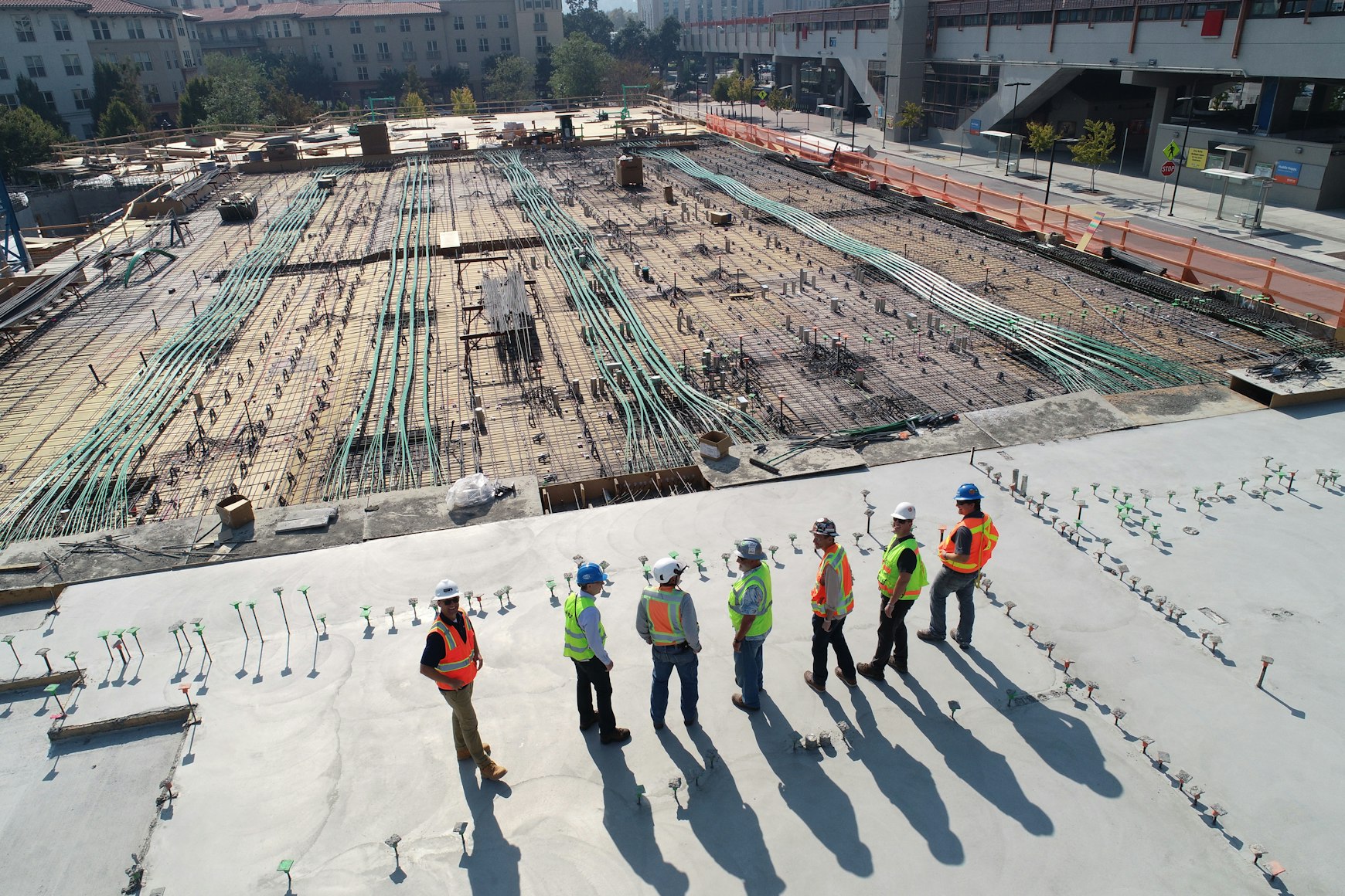 Construction site with blueprints and digital tablet showing project management software
